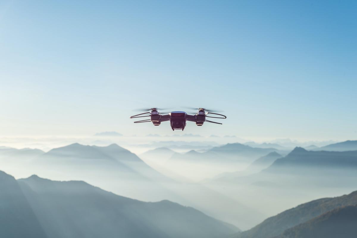 Image depicting a person holding a drone and looking at a legal document, symbolizing the importance of understanding regulations when flying drones.